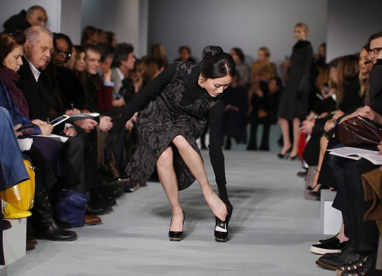 A model replaces her shoe after it slipped off while walking the runway for the Oscar de la Renta Fall 2016 collection show during Fashion Week, Tuesday, Feb. 16, 2016 in New York. (AP Photo/Julie Jacobson)